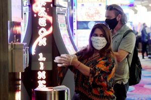 Guests take complimentary gloves from the side of a new hand-washing station at a casino in Las Vegas.