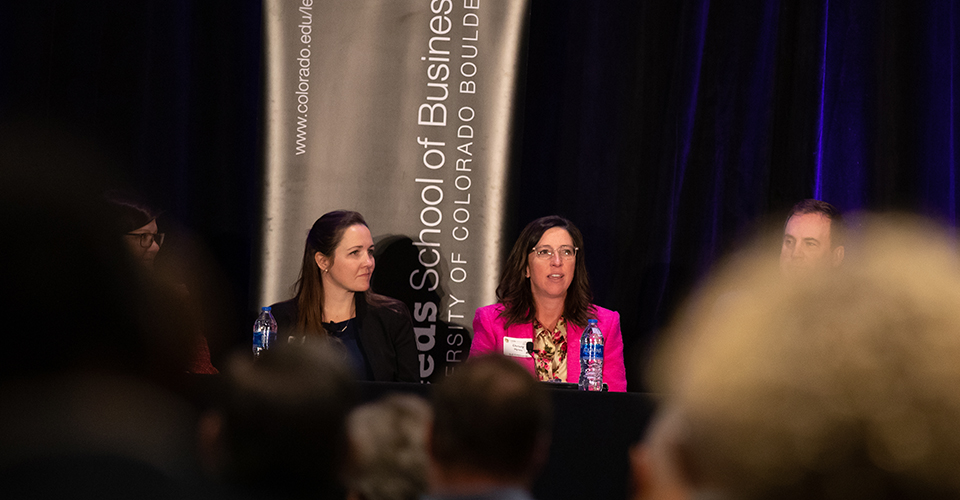 Panelists present to a packed audience at the outlook event.