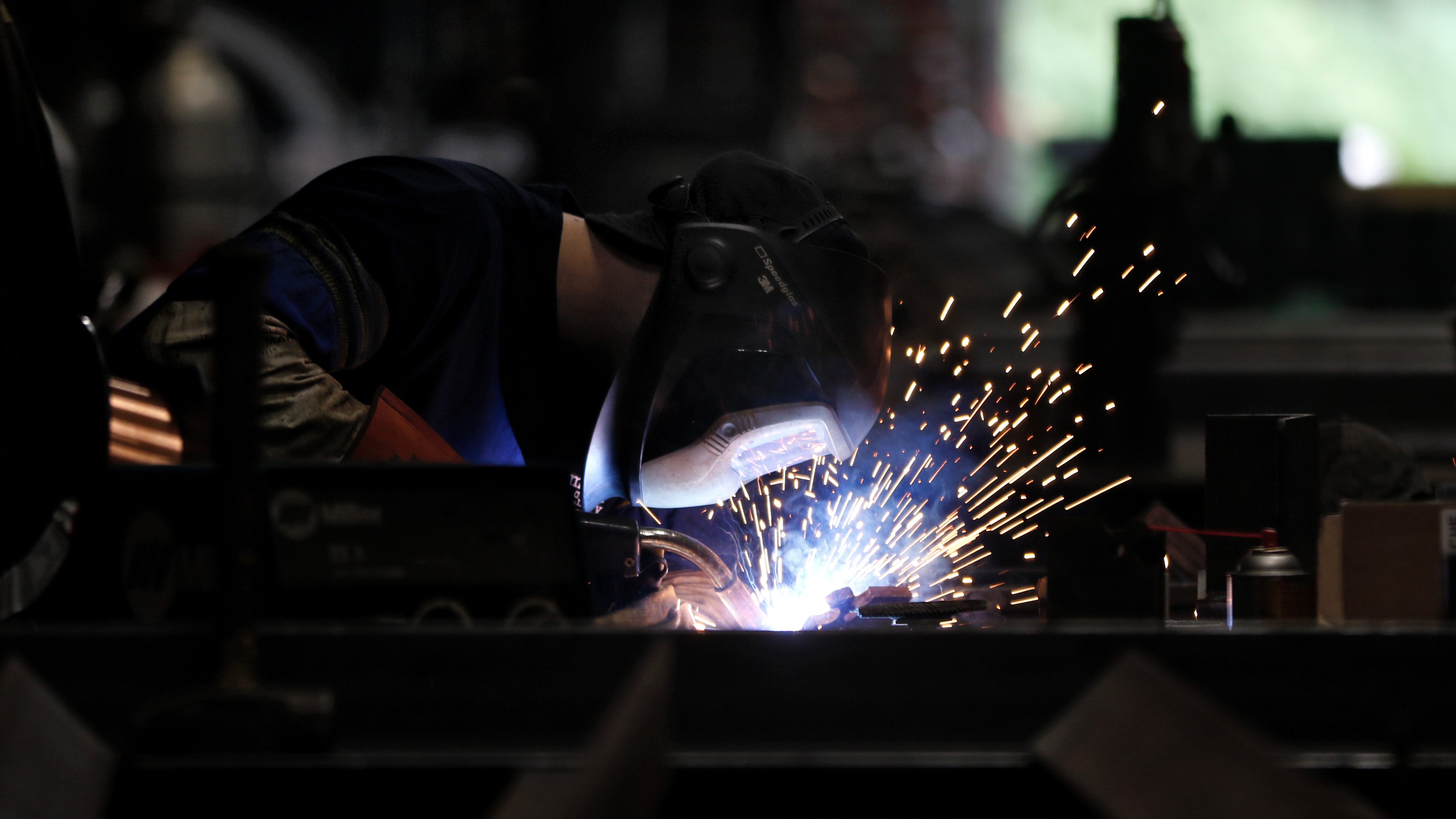 A Maxson employee welds metal together for one of the company's machines.