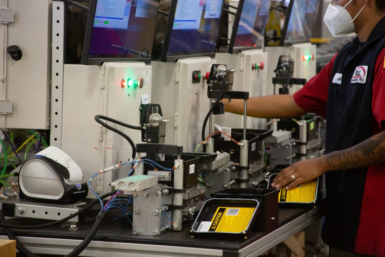 Workers manufacture air tubes for a tire system on the factory floor at Pressure Systems International.
