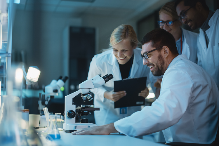 Bioengineering professionals looking at microscope 